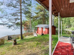 a red house on the shore of a lake at Holiday Home Koivula by Interhome in Vuoriniemi