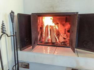 Una chimenea de ladrillo con fuego en ella en Holiday Home Kesärinne by Interhome, en Kilvakkala