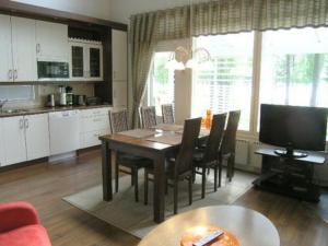 una cucina e una sala da pranzo con tavolo e sedie di Holiday Home Paltamon golfhovi a - inc- 2 x golf innin by Interhome a Paltamo