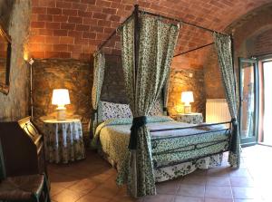 um quarto com uma cama numa parede de tijolos em Fattoria di Casalappi em Campiglia Marittima