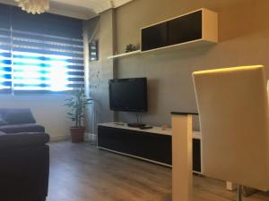 a living room with a tv and a couch at Piso cerca del Toralin y La Rosaleda in Ponferrada