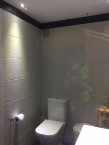 a bathroom with a white toilet and a sink at Piso cerca del Toralin y La Rosaleda in Ponferrada +8 photos