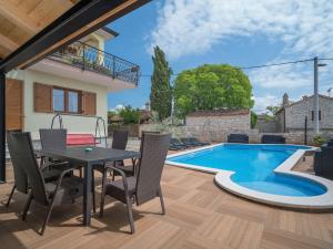 a patio with a table and chairs next to a swimming pool at Apartment Ulika-4 by Interhome in Tar