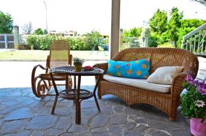a patio with a wicker couch and a table at B&B Sol Y Mar in Formia