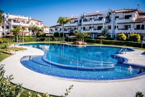 a swimming pool in a resort with buildings in the background at Apartamentos Coto de San José in Chiclana de la Frontera
