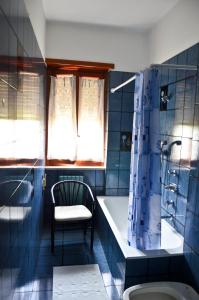 uma casa de banho com uma banheira, uma cadeira e um chuveiro em B&B Sol Y Mar em Formia