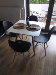 リブニクにあるApartament Fibra Moccaの白いテーブル(椅子2脚付)とワイン1本