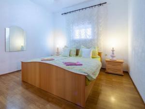 a bedroom with a large bed with a window at Apartments Anamarija in Medulin