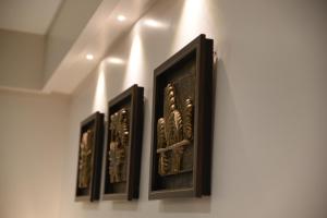a group of three framed art on a wall at HOTEL HIRISA Unit Of Hotel Fortune Palace in Jamnagar