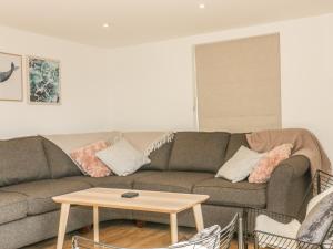 a living room with a couch and a table at The Beach Halt in Perranporth