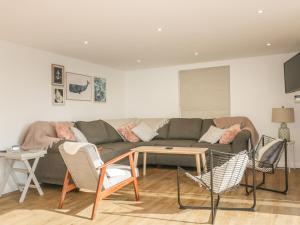 a living room with a couch and a table at The Beach Halt in Perranporth