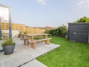 a wooden picnic table sitting on a patio at The Beach Halt in Perranporth
