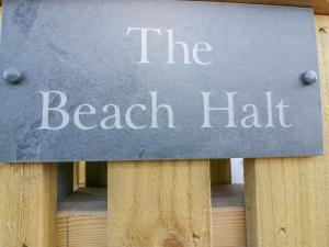 a sign that reads the beach half on a wooden table at The Beach Halt in Perranporth