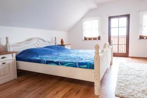um quarto com uma cama com um edredão azul em Wineyard getaway house em Sevnica