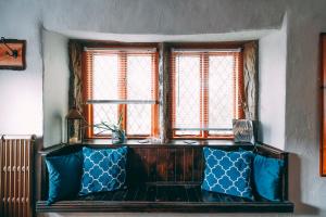 a blue couch in a room with two windows at The Rookery Nook and Brontë Parsonage - Haworth in Haworth