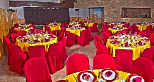 una sala banchetti con tavoli gialli e sedie rosse di El Andarrio a Buitrago del Lozoya