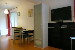 a living room with a television and a table with chairs at Apartmán Dalibor II č. 305 in Špindlerův Mlýn