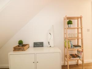 a room with a white cabinet and a book shelf at The Beach Halt in Perranporth