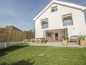 a white house with a patio and a fence at The Beach Halt in Perranporth
