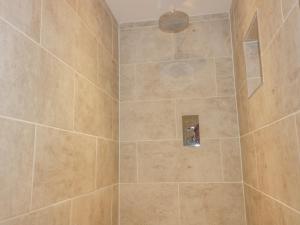 a bathroom with a shower with a tiled shower at The Beach Halt in Perranporth