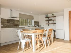 a kitchen with a wooden table and chairs at The Beach Halt in Perranporth