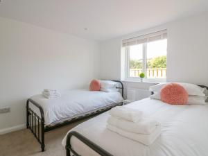 two twin beds in a room with a window at The Beach Halt in Perranporth