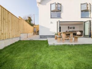 a backyard with green grass and a wooden fence at The Beach Halt in Perranporth