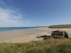 a beach with rocks and the ocean in the background at The Beach Halt in Perranporth