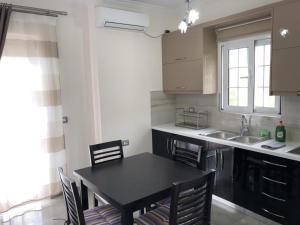a kitchen with a black table and chairs and a sink at Villa Anastasia Ksamil in Ksamil
