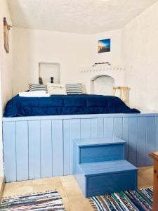 una cama azul con almohadas encima en Rhodes Summer House, en Gennadi