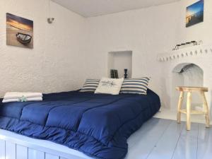 a bed with blue sheets in a white room at Rhodes Summer House in Gennadi