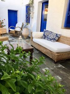 un patio con sofá, mesa y puertas azules en Rhodes Summer House, en Gennadi