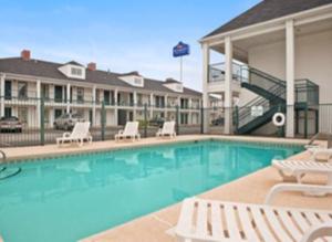 a swimming pool with chairs and a hotel at Baymont by Wyndham Sanford in Sanford