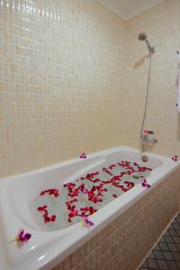 a bath tub with flowers on the floor of a bathroom at Bou Phanith Villa in Siem Reap