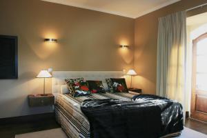 um quarto com uma cama, 2 candeeiros e uma janela em Quinta Da Pereira E Enricas Agro-Turismo em Vila Flor