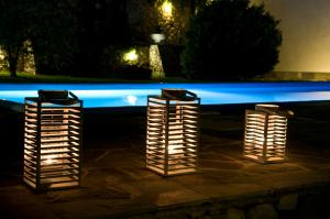 a group of three lights sitting next to a pool at night at Villa Spartias in Skiathos