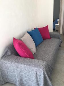 a gray couch with four pillows on it at Casa Vigna da Michela in Favignana