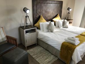 een hotelkamer met 2 bedden en een stoel bij Bush Pillow Guest House in Otjiwarongo