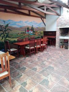 una sala da pranzo con tavolo, sedie e murale di The Olde House a Port Elizabeth