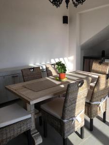 a dining room table with wicker chairs and a wooden table with a plant at Casa Vigna da Michela in Favignana