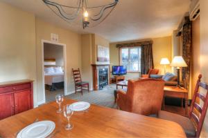 a room with a dining table and a living room at Place Saint Bernard Mont Tremblant in Mont-Tremblant