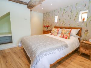 a bedroom with a bed with a floral wallpaper at The Tractor Shed in Oswestry
