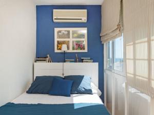 Schlafzimmer mit blauen Wänden und einem Bett mit blauen Kissen in der Unterkunft Apartment Eurosol-2 by Interhome in Torremolinos