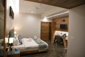 a hotel room with a bed and a desk at HOTEL HIRISA Unit Of Hotel Fortune Palace in Jamnagar