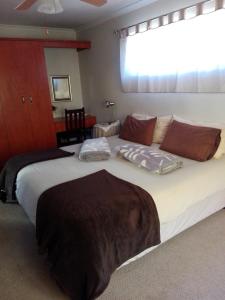 a large white bed in a room with a window at The Olde House in Port Elizabeth
