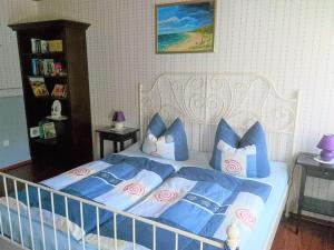 ヴィーク・アウフ・リューゲンにあるFantastic Apartment in Wiek with Gardenのベッドルーム1室(青と白の枕が備わるベッド1台付)