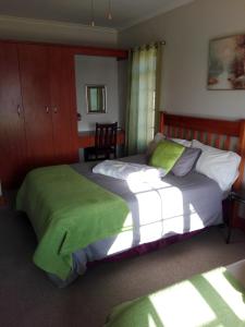 una camera con due letti con coperte verdi di The Olde House a Port Elizabeth