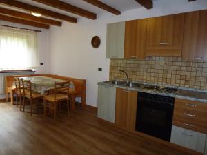 a kitchen with a table and a sink and a stove at Casa Angela in Predazzo