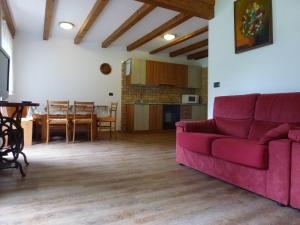 a living room with a red couch and a table at Casa Angela in Predazzo