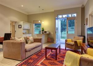 a living room with a couch and a table at Gaikou Lodge in Swellendam